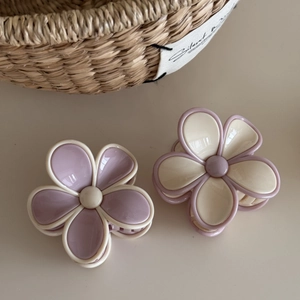 Close-up of dual-tone flower hair claws in cream white and lavender with glossy resin finish