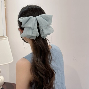 Pale blue-green plaid tulle bow hair claw clip with crystal pendants on long wavy hair