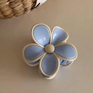 Detail view of the light blue and cream two-tone floral hair claw clip in high-gloss resin