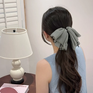Elegant houndstooth bow hair claw clip with crystal pendant shown on model's ponytail