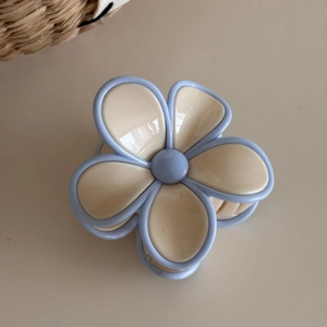 Close-up of light blue and beige flower hair claw clip with a glossy finish for hair styling