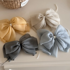 Detailed view of four colorful tulle plaid bow hair clips with delicate beaded edges