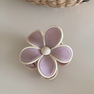 Detail shot of a flower hair claw clip in lotus pink and cream white matte resin