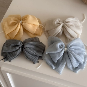 Detailed close-up of colorful tulle plaid bow hair clips with crystal pendant accents