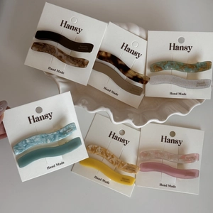 Lot de barrettes à cheveux ondulées en acétate de diverses couleurs sur carte blanche