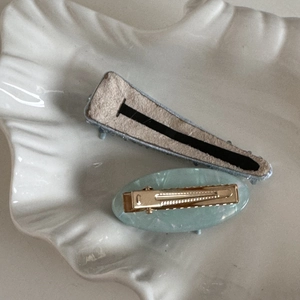 Dettaglio di fermagli per capelli in resina marmorizzata e feltro su vassoio