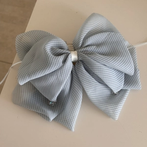 Detail of blue gingham bow hair clip with white satin center and crystal bead charms