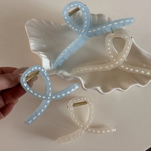 Blue and white bow hair clips with dotted patterns and gold metal springs