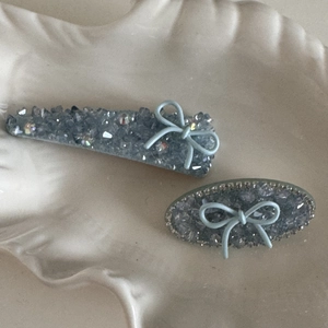 Eleganti fermagli per capelli blu con fiocchi su un vassoio di ceramica