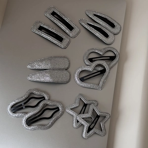 Détails de barrettes argentées pailletées en formes de cœur et étoile sur métal