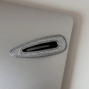 Détail d'une barrette à paillettes argentées avec structure BB et coutures de précision