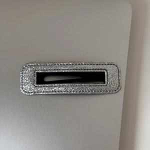 Détail d'une barrette rectangulaire pailletée argentée avec structure évidée et clip