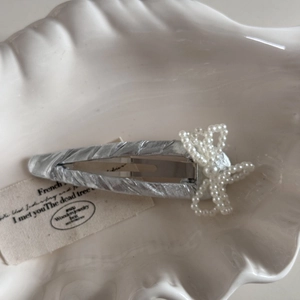 Elegante fermaglio per capelli in tessuto plissettato argento con fiocco di perle