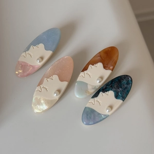 Artistic oval hair clips with side profile relief and pearl details in multiple colors