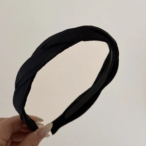 Gros plan du serre-tête torsadé en tissu noir montrant la texture et les dents antidérapantes