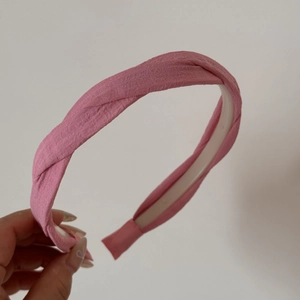 Détail de la texture du tissu du serre-tête rose torsadé et des dents antidérapantes internes