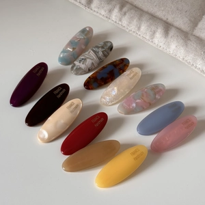 Close-up of handmade oval acetate hair clips in assorted macaron and marble colors