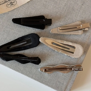Detailed back view of five silver and black polka dot hair clips with metallic finish