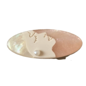 Elegant oval hair clip with profile portrait relief and pearl accent in cream resin