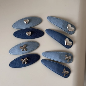 Vue détaillée des barrettes en denim bleu avec ornements en métal argenté en forme de coeur