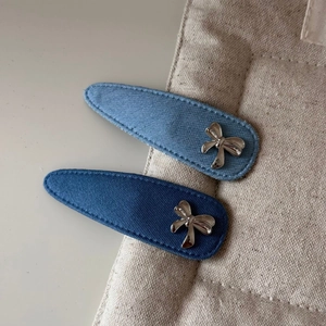Vue macro détaillée de barrettes en denim avec ornements en forme de cœur et nœud argenté