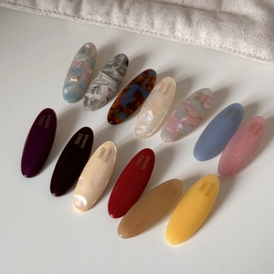 Macro shot of 12 colorful oval acetate hair clips with France Handmade gold lettering