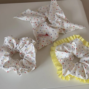 Lot de trois chouchous en tissu blanc avec pois colorés et détail de nœud papillon