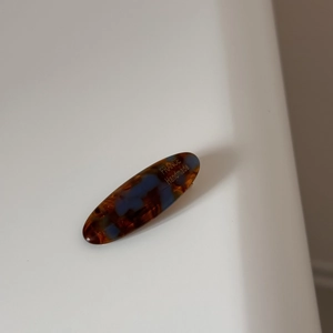 Macro shot of tortoise shell acetate oval barrette with golden France Handmade lettering