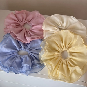 Détail de quatre chouchous en mousseline superposée aux tons pastels de macarons