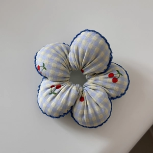 Detail of blue plaid floral scrunchie with cherry prints and scalloped wavy edges