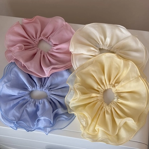 Détail de quatre chouchous en mousseline aux couleurs macaron avec bords volantés