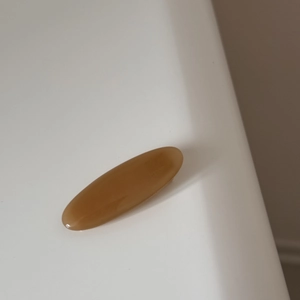 Macro detail of amber oval resin hair clip showing smooth texture and Handmade engraving