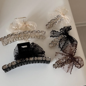 Detail view of lace polka dot bow hair clips with crystals and resin shark clips