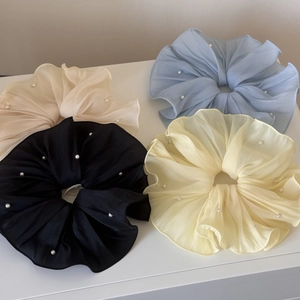 Detailed macro view of chiffon scrunchies with white pearls in four pastel colors