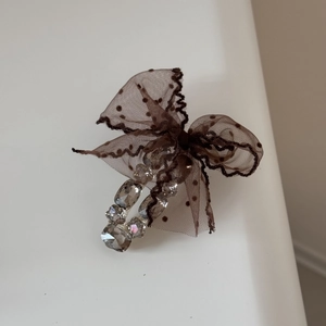 Detail of coffee brown polka dot lace bow hair claw clip with sparkling rhinestones