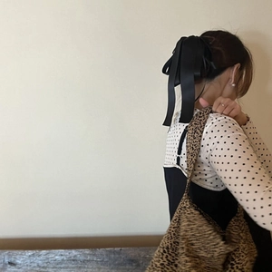 Détail d'une grande pince à cheveux avec nœud en satin noir et longs rubans élégants