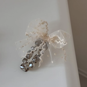 Macro detail of tulle polka dot bow with grey faceted rhinestones on a stylish hair claw