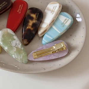 Barrettes à cheveux en acétate rose et marbré dans un plateau en céramique pour filles