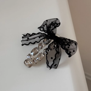 Detail view of lace polka dot bow hair claw with sparkling rhinestones and black mesh