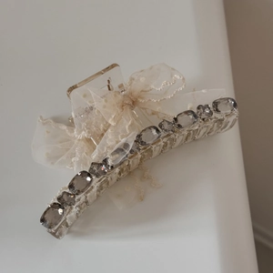 Macro detail of tulle polka dot bow hair claw with sparkling rhinestones and acrylic clip
