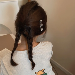 Silver bow hair clip styled on a brown braided hairstyle for a sweet Korean look