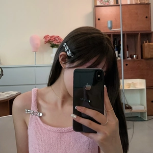 Close-up of a silver liquid metal hairpin used as a fashion clip on a pink knit vest
