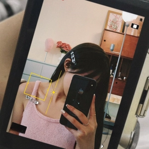 Detailed texture of pink knit vest with metallic silver accents in a stylish mirror selfie