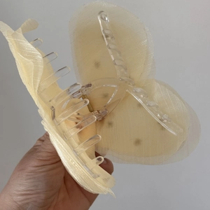 Dettaglio molletta per capelli a farfalla in tulle giallo con strass stile francese