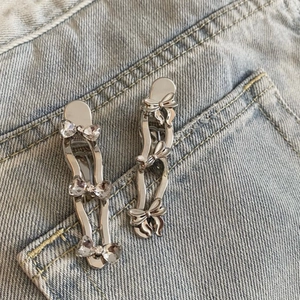 Detail of silver bow hair clips with rhinestones on denim fabric for a sweet fashion look