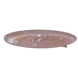 Pink translucent resin shell hair clip with gold metal base on a white background