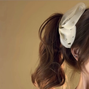 Dettaglio del fermaglio a farfalla in tulle con strass e decorazione dorata Love elegante