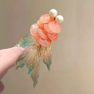 Detail der handgefertigten Goldfisch-Haarspange mit rosa Schuppen und Perlenakzenten