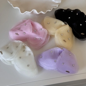 Dettaglio di fermagli per capelli in tulle multicolore con strass e ciondoli in metallo Love