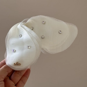Dettaglio molletta a farfalla in tulle bianco con strass e scritta Love dorata